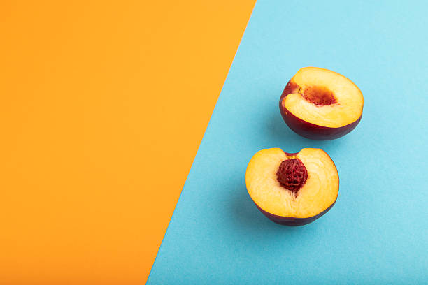 Peach Cut in half on orange and blue paper pastel, Side view, copy space