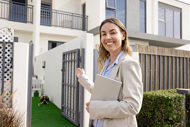 Professional mature woman with short hair outdoors in a business setting holding keys, symbolizing confidence, success, and professionalism in an urban environment. Ideal for concepts of work, achievement, and real estate.