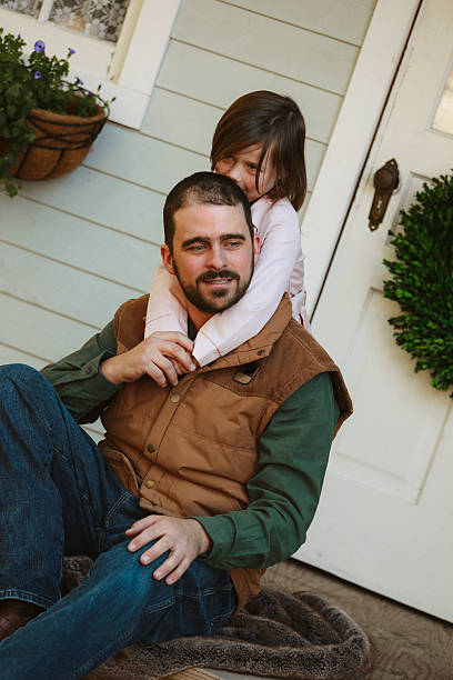 istock Father and Daughter on Front Porch Hugging 2248372647
