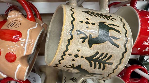 Close-Up of Rustic Ceramic Christmas Mug with Nordic Reindeer and Pine Tree Pattern – Handcrafted Holiday Stoneware Cup Displayed on Store Shelf