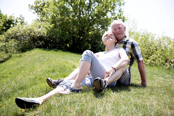 Back view happy lovely gray haired senior married couple sitting bench talk discuss hugging city park outside. Romantic aged man woman embrace talking outdoors enjoying date together retirement relax. High quality 4k footage