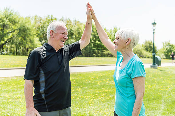istock Senior couple running in park doing high five 2248376968