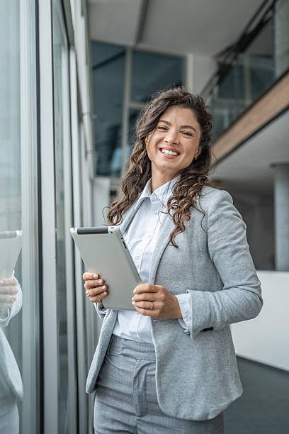 istock Smiling businesswoman holding a tablet in modern office 2248377512