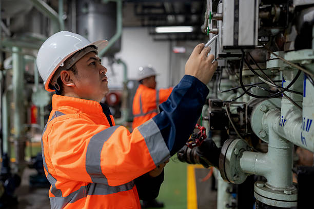 istock A mechanical engineer in safety gear adjusts pressure system parameters while monitoring gauges Ensuring valves remain in proper range. He synchronizes data with a digital tablet in an oil production plant Enhancing efficiency safety 2248377673