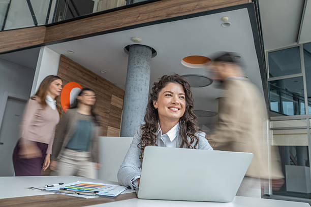 istock Businesswoman smiling in busy open-plan office environment 2248378577
