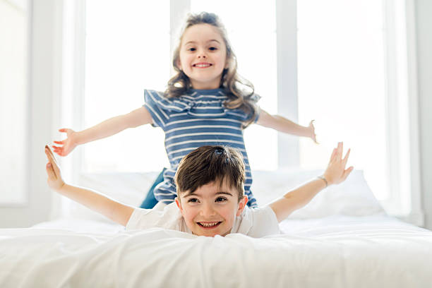 istock Brother And Sister having fun Together on Bed 2248379258
