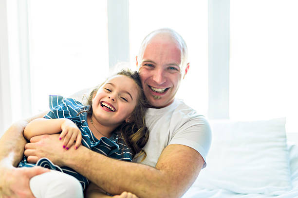 istock Happy father and daughter having fun together on a bed 2248379343