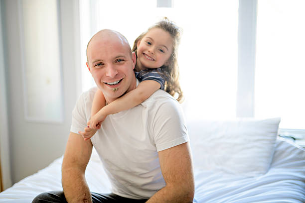 istock Happy father and daughter having fun together on a bed 2248379361
