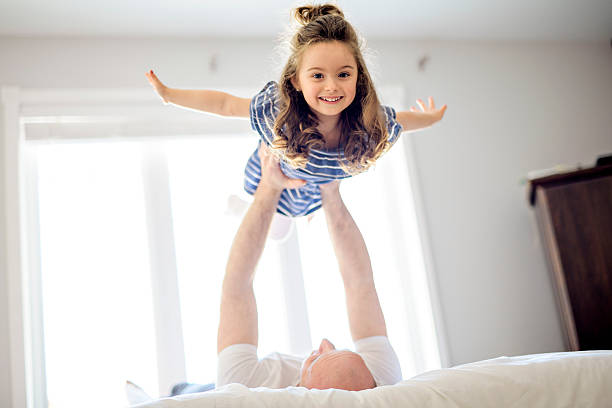 istock Happy father and daughter having fun together on a bed 2248379368