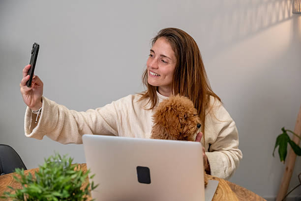 istock Woman and dog taking selfie while working from home 2248381629