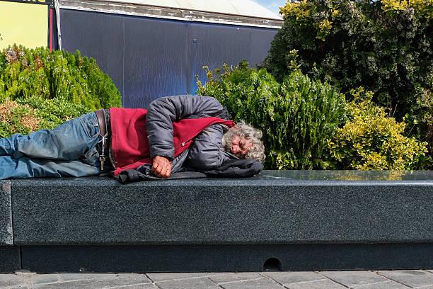 The young man has a cold and is lying in bed at home because he is too sick to go out.