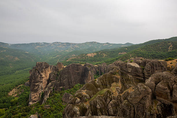 Unesco world heritage site meteora landscape featuring unique rock formations and green valleys under a cloudy sky, showcasing unesco world heritage site geology. Meteora, greece