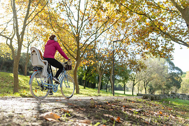 istock Woman cycling on park path during autumn day 2248383358