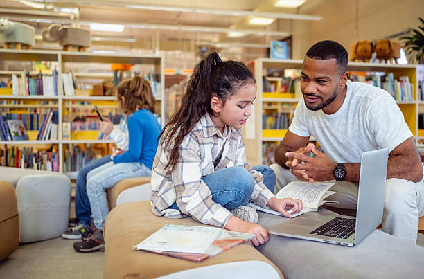 istock Engaged Multiracial Teacher Assisting Young Student with Laptop in Library 2248386092