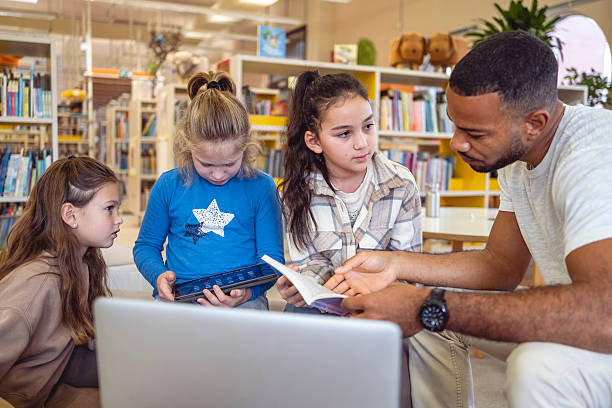 istock Engaged Multiracial Educator Guiding Young Learners in Modern Library 2248386114