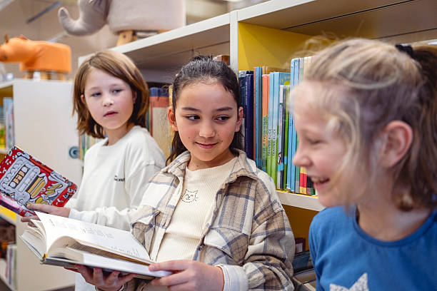 istock Diverse Boy and Girl Sharing Laughter While Reading in Library 2248386126