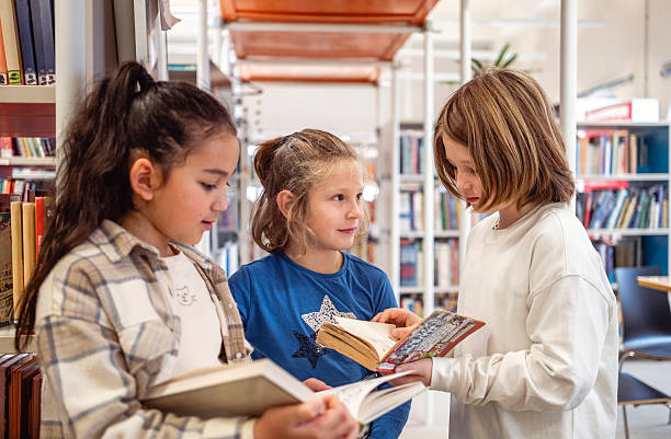 istock Diverse Boys and Girls Engaging in Animated Library Book Conversation 2248386133