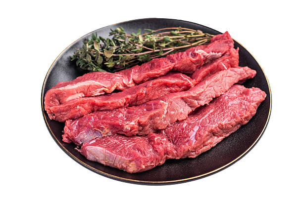 Raw sliced horse meat steaks presented with herbs and spices, inviting creativity in the kitchen for those seeking bold flavors and unique dining experiences. isolated on white background. top view