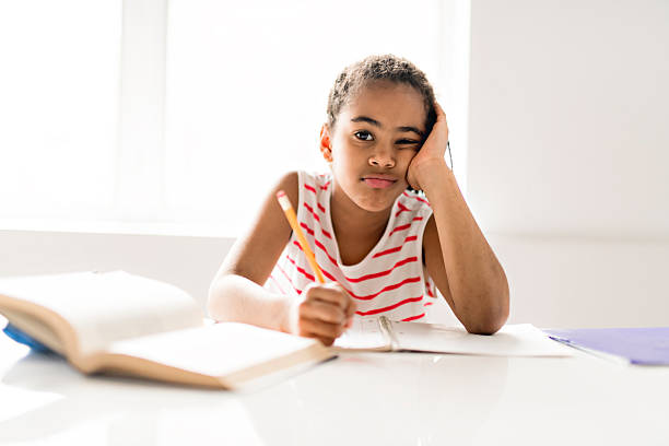istock A cute Black girl doing homework at home 2248391177