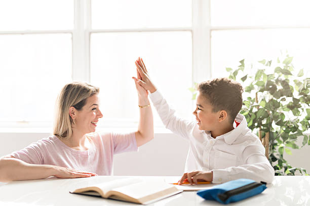 istock mother help Black boy doing homework at home 2248391427