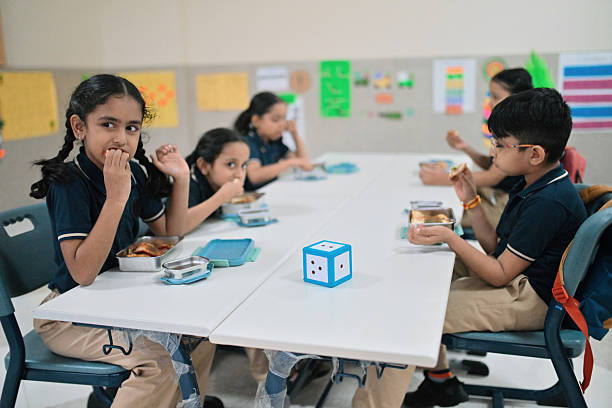 Smiling school students in uniform missing a tooth with a healthy sandwich for lunch