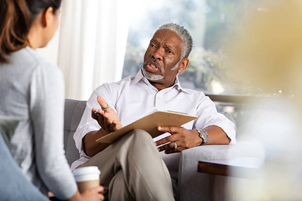istock Therapist with clipboard guides client through discussion session for emotional support. 2248392916