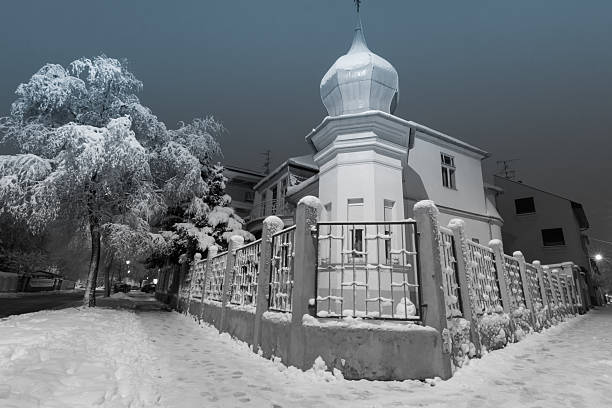 City snowfall at night with empty streets. Streets and trees of the city after a snowfall