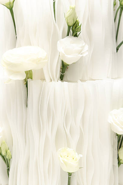 Soft white flowers emerging through delicate flowing fabric layers create an elegant, airy composition with a serene, minimalist aesthetic perfect for wedding, luxury, and beauty themes.