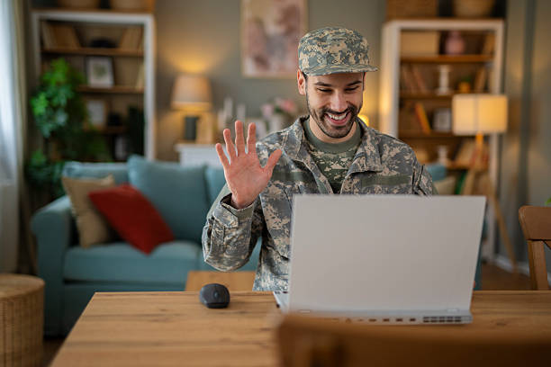 istock Soldier smiling making video call on laptop 2248394530