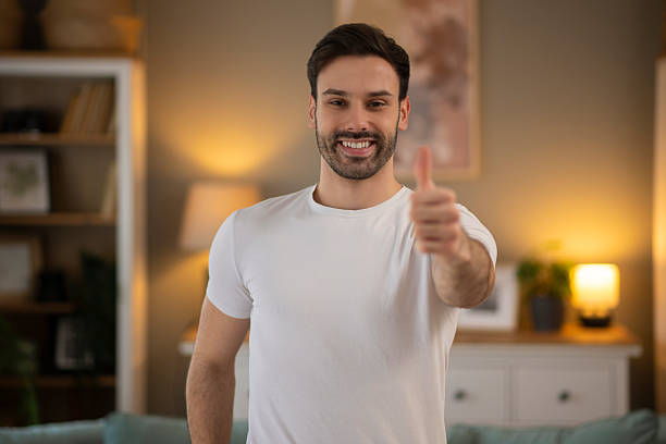 istock Young man smiling giving thumbs up gesture 2248394560