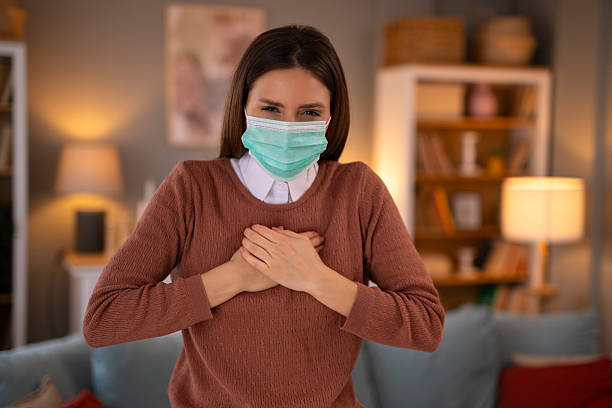 istock Woman wearing a face mask expressing gratitude at home 2248394630