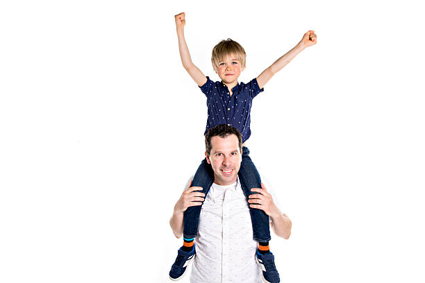 Father and son sitting on stool, laughing and showing fun gesture joyful family relationship concept