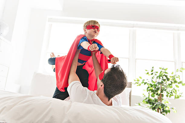 istock Father and son play superheroes on bed at home 2248395577
