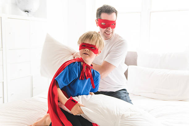 istock Father and son play superheroes on bed at home 2248395617