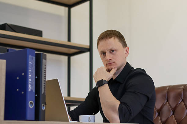 istock Young professional in thoughtful pose with hand on chin in office 2248399526
