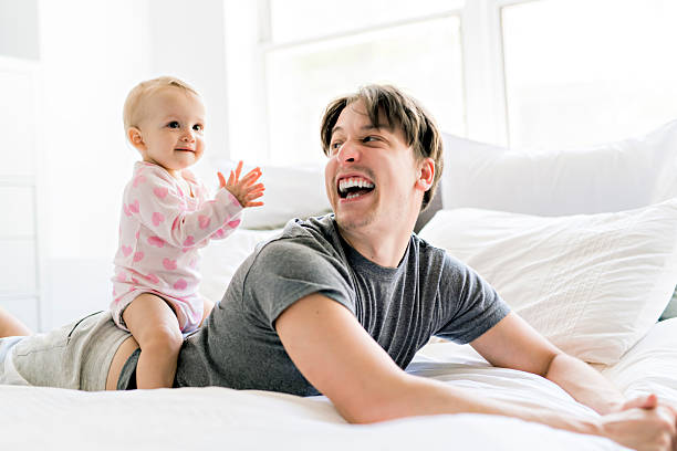istock Happy father with baby lying on bed at home 2248399711