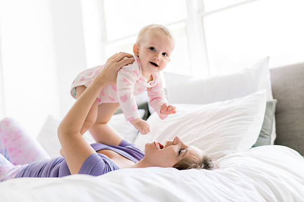 istock Happy mother with baby lying on bed at home 2248400262