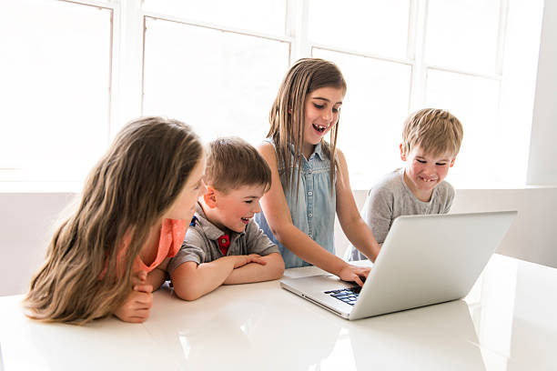 istock Group of curious children watching stuff on the laptop screen 2248400421