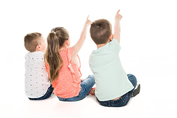 istock Back view of child group sitting on floor looking at wall 2248400560