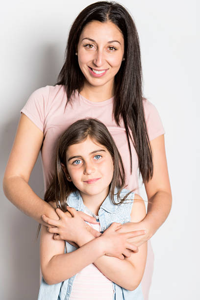 istock pretty mother standing with her cute daughter 2248400640