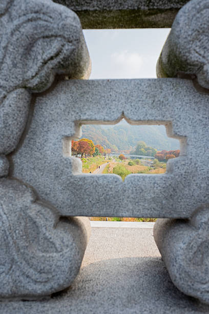 istock Ornate granite window framing an autumn walking path with colorful trees and distant mountains 2248401551