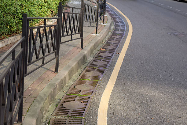 istock Sidewalk railing along curved street with drainage system 2248401873