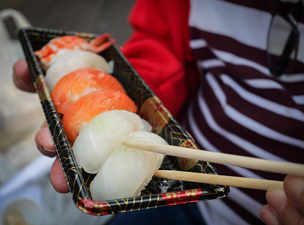 Close-up of a sushi tray with chopsticks ready on the side.