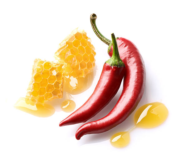 istock Honeycomb and hot red peppers on white background 2248403499