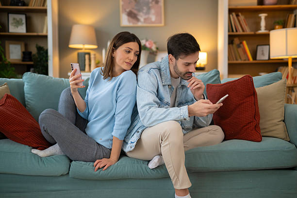istock Woman peeking at man's smartphone displaying relationship distrust 2248404194