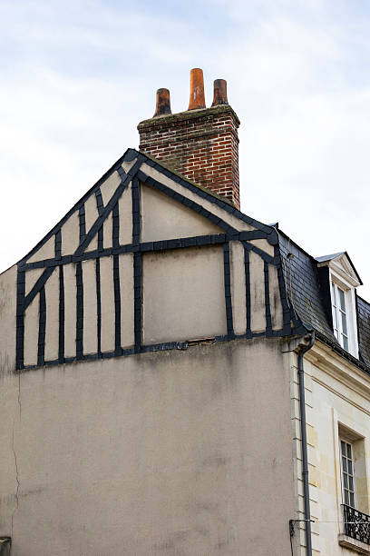 istock Historic building gable with black slate tiles pattern and a red brick chimney stands in Tours France creating a beautiful traditional medieval city architecture view against the cloudy sky 2248404476