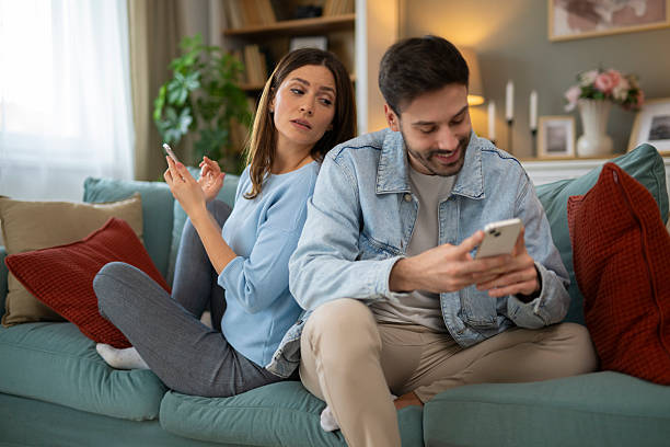 istock Woman spying on man's phone, feeling distrust 2248404593