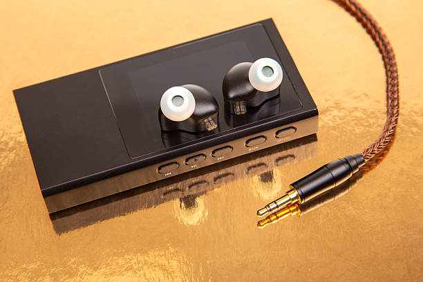 istock High-quality audio device with earphones on a reflective surface in a well-lit setting 2248404622