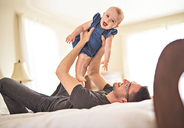 istock Father playing with her baby in the bedroom 2248404772