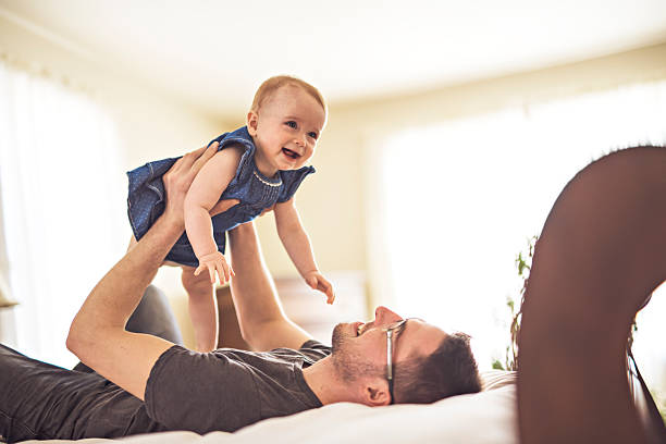 istock Father playing with her baby in the bedroom 2248404773